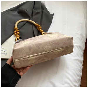 Dettaglio ravvicinato della borsa tote in tela floreale vintage con manici in legno
