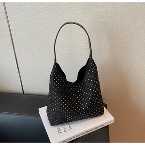 Close-up of black rhinestone hobo bag with sparkling crystals on white art books