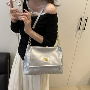 Silver metallic underarm bag with animal scale texture and gold chain strap