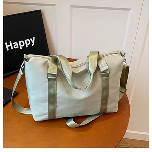 Macro detail of the light green oxford travel bag showing handles and adjustable strap