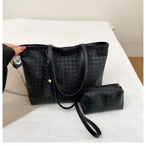 Detail view of the black houndstooth pattern texture on the tote and pouch set