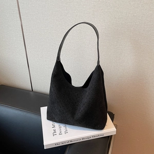 Fashionable black rhinestone hobo shoulder bag placed on a book for a minimalist aesthetic