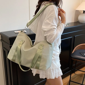 Large pale green nylon travel tote bag with adjustable shoulder strap and metal hardware