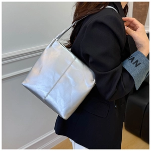 Detail shot of the metallic silver shoulder bag showing the premium leather texture