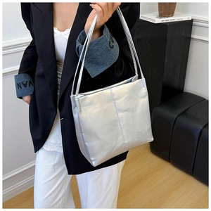 Detail view of metallic silver shoulder bag showing glossy texture and dual strap design