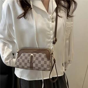 Classic crossbody bag with brown leather trim and vintage monogram pattern on a model