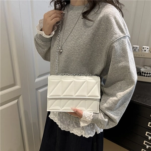 Bolso bandolera blanco con pespuntes triangulares y correa de cadena plateada