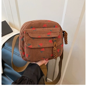 Close-up of strawberry print corduroy crossbody bag with adjustable strap and zipper