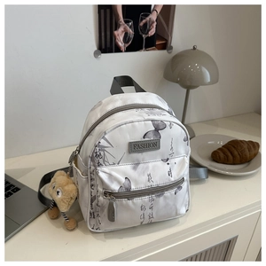 Detail view of mini white nylon backpack featuring classic butterfly print and plush charm