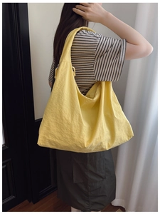 Vue latérale d'un grand cabas en nylon jaune vif avec texture plissée sur un mannequin