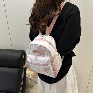 Mini backpack for women featuring pink butterfly prints and a cute plush charm accessory