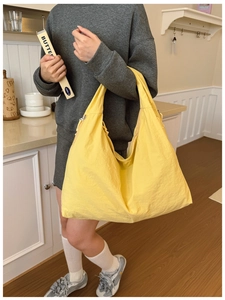 Gros plan sur le sac d'épaule en nylon jaune avec texture naturelle et grande capacité