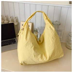 Détail d'un grand sac hobo en nylon jaune dans une scène de vie intérieure cosy