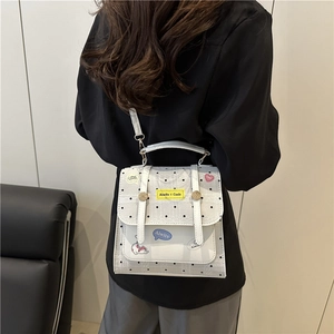 White polka dot mini crossbody bag with cartoon appliques shown on model for daily style