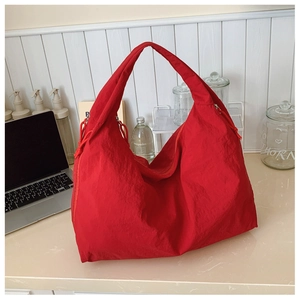 Vue détaillée du sac cabas en nylon rouge avec tissu texturé et détails ajustables