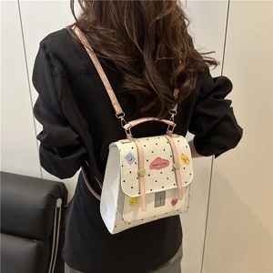 Chic white polka dot leather backpack with pink straps and trendy cartoon patches