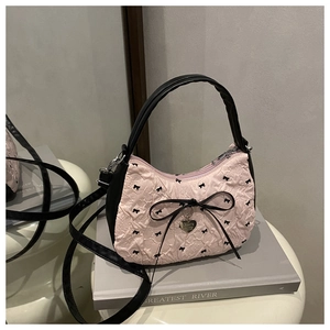 Detail of pink bubble texture bag with black bow and metallic heart pendant