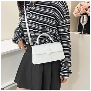 Detail of white minimalist square bag with vertical stitching and round handle