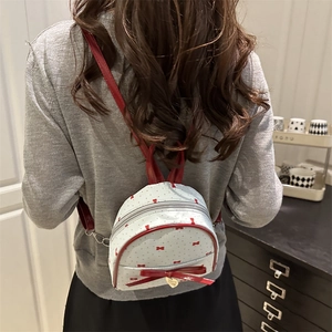 Mini backpack with red bows and polka dots shown on a model for daily use