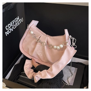 Detail of pink satin baguette bag featuring pearl daisy chain and embroidered brand label