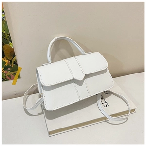 Detailed close-up of white minimalist square crossbody bag with textured faux leather finish