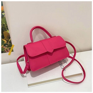 Detailed view of hot pink square handbag with V-shaped stitching and top handle