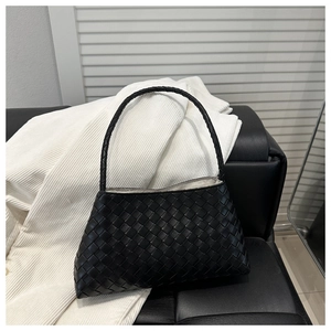 Close-up detail of iconic woven leather texture and interior silver lining of the tote bag