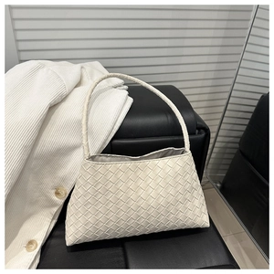 Close-up of the cream woven leather texture and Intrecciato style craftsmanship on handbag