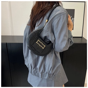 Detail of black crocodile texture leather shoulder bag with golden square buckle clasp