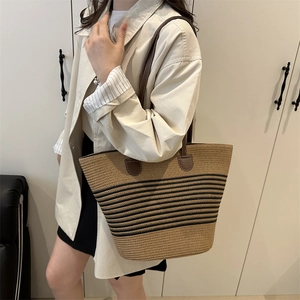 Large raffia tote bag with black stripes and brown leather straps for summer vacation