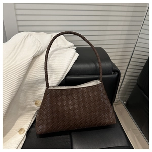 Detail view of brown woven leather hobo bag showing the intricate intrecciato texture