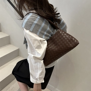 Dark brown woven leather hobo shoulder bag with Intrecciato pattern worn by a model