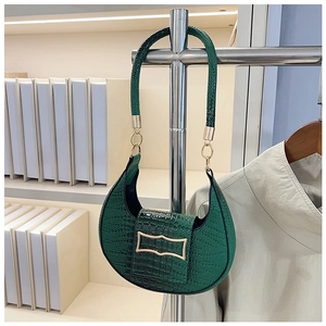 Detailed macro of dark green faux crocodile leather texture and golden buckle on bag
