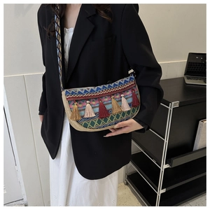 Close-up of ethnic crossbody bag with geometric embroidery and colorful tassels
