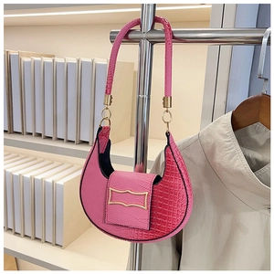Detail view of pink croc-embossed crescent handbag with elegant gold metal buckle hardware