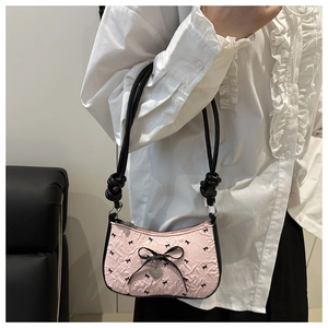 Detail of pink bubble fabric bag with black bow patterns and heart-shaped metal pendant