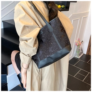 Chic black and white polka dot tote bag styled with a professional camel trench coat