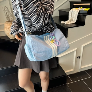 Blue canvas barrel gym bag with white stripes and star charm for summer casual wear