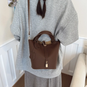 Deep brown bucket bag with lychee grain leather, dual handles and smile charm