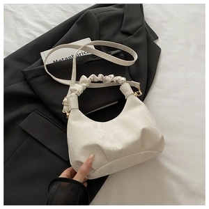 Detail of white marble-pattern handbag with pleated handle and gold hardware