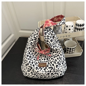 Detail of leopard print canvas tote bag featuring pink bow and heart pattern lining
