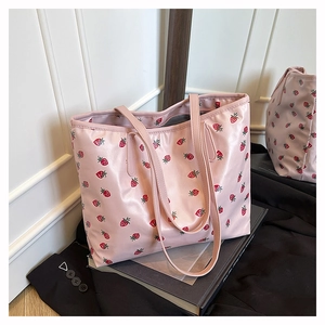Détail du sac cabas rose avec imprimé fraises et texture en nylon résistant à l'eau