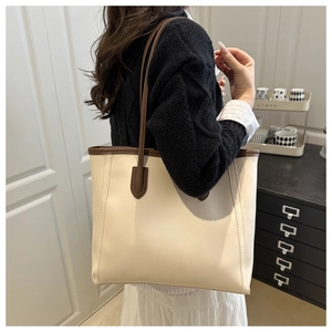 Detail of minimalist cream tote bag with brown handles and high-quality PU leather stitching