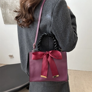 Deep red bridal handbag with bow decor, woven handle and shoulder strap in retro style