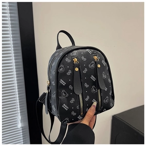 Gros plan du sac à dos noir avec fermeture dorée et motifs d'oursons mignons