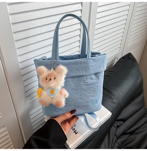 Détail du sac fourre-tout en nylon plissé bleu clair avec ours en peluche et logo