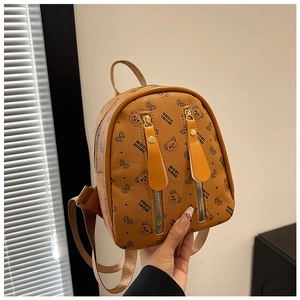 Détail d'un mini sac à dos en similicuir marron avec motifs d'ours et zips verticaux