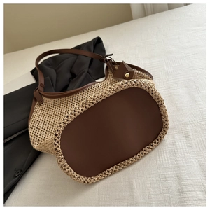 Détail du sac cabas en paille avec finitions en cuir marron et boucles dorées