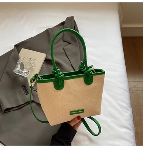 Détail de la garniture en cuir vert et texture tissée d'un grand sac à bandoulière chic