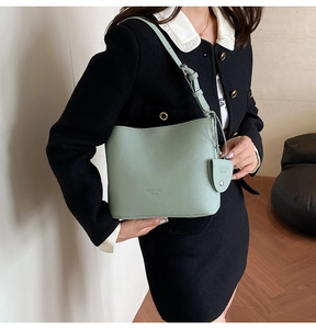 Detail of the light green lychee textured leather bucket bag with an adjustable strap
